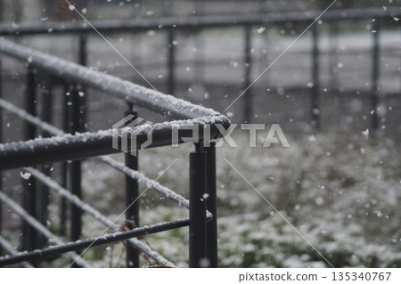 Snow falls on a railing in a city during winter Snow falls on a railing in a city during winter 135340767