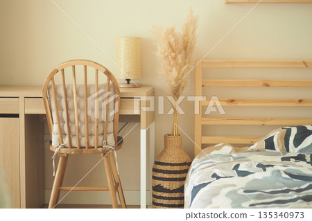 Simple room with chair, desk, and bed in neutral tones Simple room with chair, desk, and bed in neutral tones 135340973