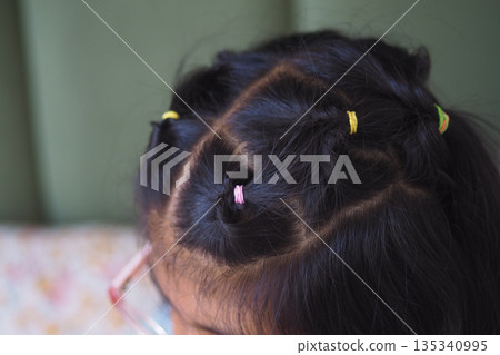 Child with colorful hair ties in unique hairstyle Child with colorful hair ties in unique hairstyle 135340995
