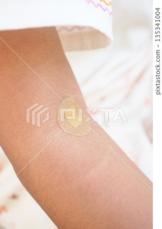 Bandage on an child arm after a minor injury in a home setting Bandage on an child arm after a minor injury in a home setting 135341004