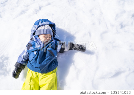男孩躺在雪地上 135341033