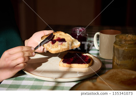 Family Breakfast Moment With Peanut Butter And Jelly Toast On Checkered Tablecloth Family Breakfast Moment With Peanut Butter And Jelly Toast On Checkered Tablecloth 135341073