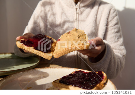 Cozy Breakfast Moment: Peanut Butter And Jelly Toast Slices Shared At The Table Cozy Breakfast Moment: Peanut Butter And Jelly Toast Slices Shared At The Table 135341081