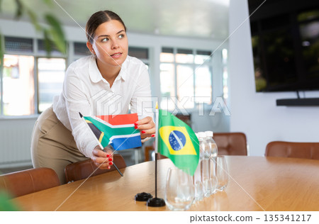 Positive young woman putting little flag of South Africa on table next to the flag of Brazil Positive young woman putting little flag of South Africa on table next to the flag of Brazil 135341217