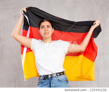 Sad young woman holding Germany flag 135341238