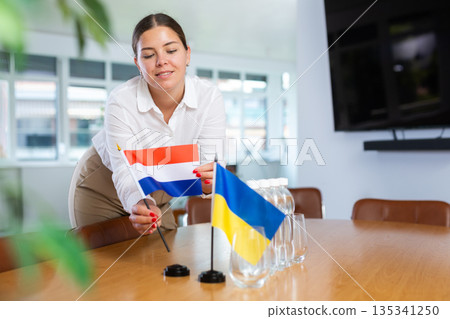 Businesswoman placing flags of Netherlands and Ukraine on negotiating table Businesswoman placing flags of Netherlands and Ukraine on negotiating table 135341250