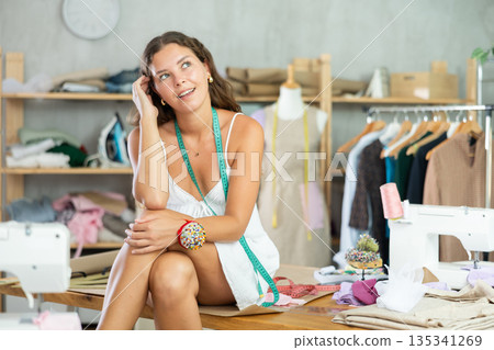 Woman Tailor Sitting On Table Woman Tailor Sitting On Table 135341269