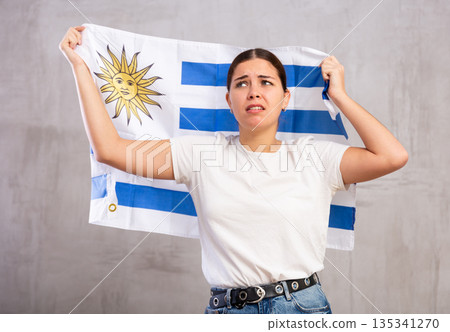 Sad young woman holding Uruguay flag Sad young woman holding Uruguay flag 135341270