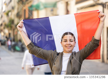 Happy female tourist walking old streets with flag of france 135341296
