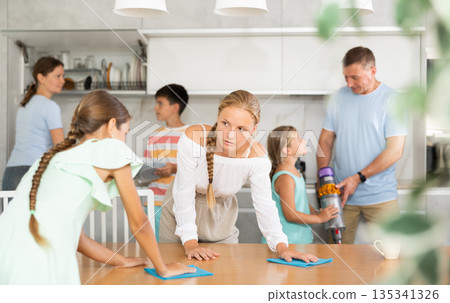 Teenage girls wash dining tables and help to do household chores, family day. Teenage girls wash dining tables and help to do household chores, family day. 135341326