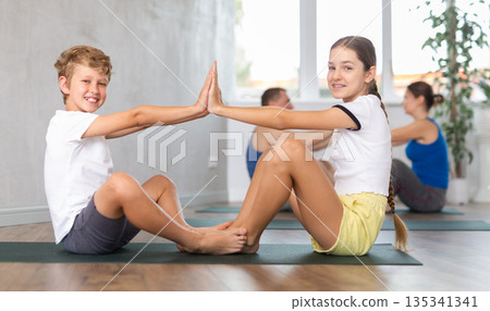 Happy sister and brother practicing yoga poses Happy sister and brother practicing yoga poses 135341341