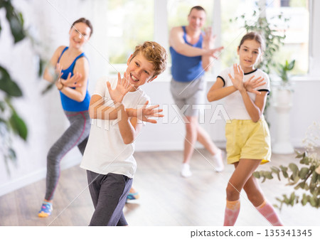 Positive pre-teenage dancers and parent doing dance workout during group class Positive pre-teenage dancers and parent doing dance workout during group class 135341345