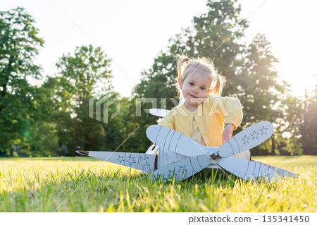 Pretend play child. Girl aviation pilot toy. Summer fun outdoor Pretend play child. Girl aviation pilot toy. Summer fun outdoor 135341450