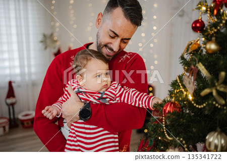 Happy father son decorating Christmas tree celebration 135341722
