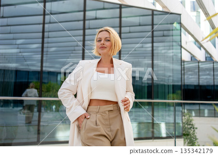 Confident businesswoman in blazer posing near 135342179
