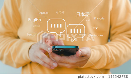 Person using smartphone with multilingual chat icons, representing global communication, language translation, online messaging, and international connection through modern mobile technology. Person using smartphone with multilingual chat icons, representing global communication, language translation, online messaging, and international connection through modern mobile technology. 135342788