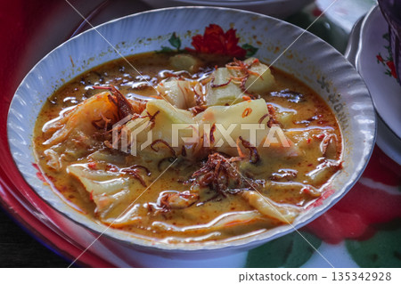 Authentic Lombok Begawe Dish: A Rich Coconut Milk Curry Stew Featuring Traditional Spices and Served in Decorative Bowl for Cultural Culinary Experience Authentic Lombok Begawe Dish: A Rich Coconut Milk Curry Stew Featuring Traditional Spices and Served in Decorative Bowl for Cultural Culinary Experience 135342928