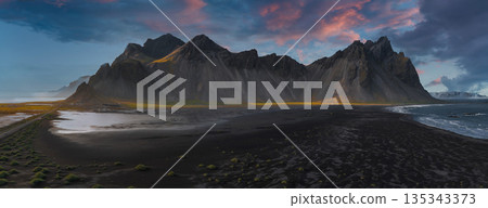 The Stokksnes Peninsula features Vestrahorn's jagged peaks, a black sand beach, gentle waves, green moss, and a colorful sunset sky. The Stokksnes Peninsula features Vestrahorn's jagged peaks, a black sand beach, gentle waves, green moss, and a colorful sunset sky. 135343373