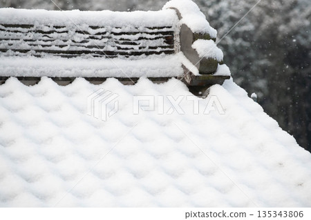 老房子的瓦片屋頂上積滿了雪 135343806