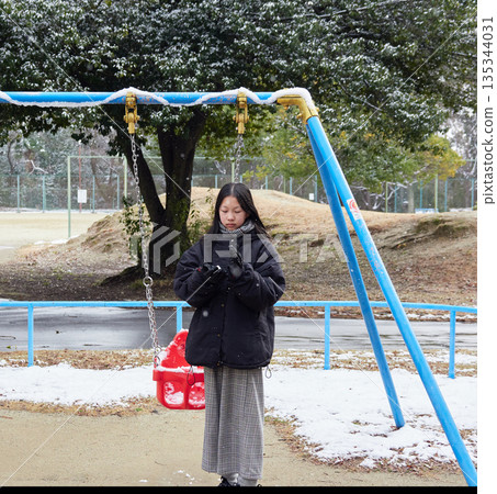 冬日清晨,一個小女孩在白雪皚皚的公園裡玩雪仗,玩得不亦樂乎。 冬日清晨,一個小女孩在白雪皚皚的公園裡玩雪仗,玩得不亦樂乎。 135344031