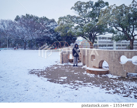 A female junior high school student playing in the snow in a park in winter 135344077