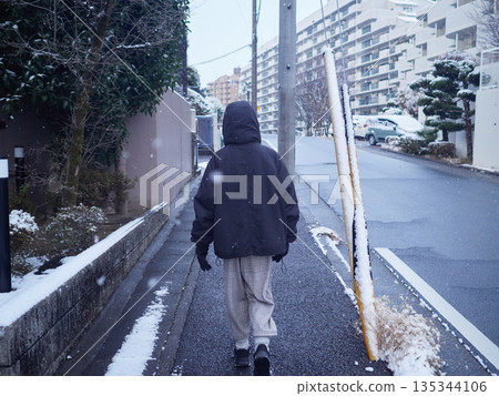 A young girl walking in a snowy residential area on a winter morning A young girl walking in a snowy residential area on a winter morning 135344106