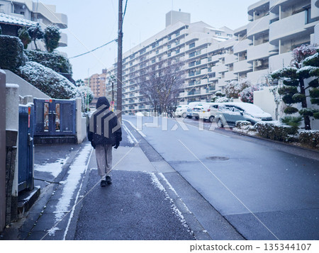 A young girl walking in a snowy residential area on a winter morning A young girl walking in a snowy residential area on a winter morning 135344107