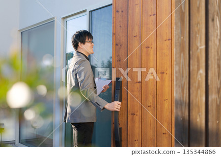 一名男子正在拜訪一戶人家 一名男子正在拜訪一戶人家 135344866