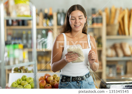 Young woman choosing oat flakes in grocery store 135345545