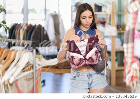 Young woman chooses underwear in clothing store 135345629