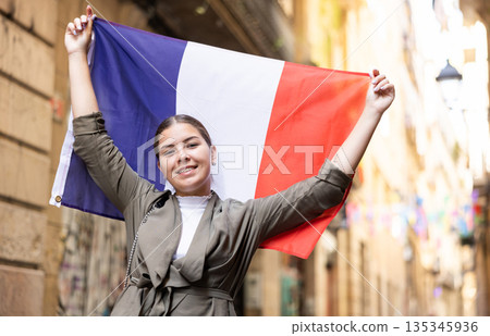 Young smiling woman holding France flag Young smiling woman holding France flag 135345936