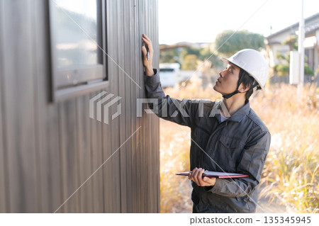 Site supervisor checking the exterior wall Site supervisor checking the exterior wall 135345945