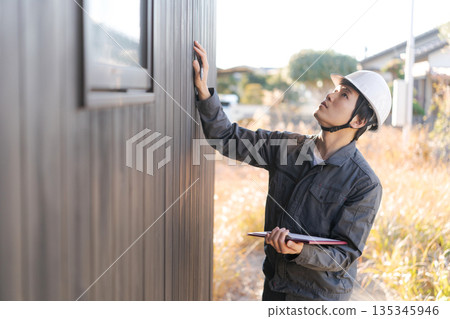Site supervisor checking the exterior wall Site supervisor checking the exterior wall 135345946