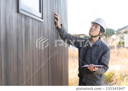 Site supervisor checking the exterior wall 135345947