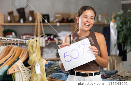 Woman holding a poster with a discount Woman holding a poster with a discount 135345991
