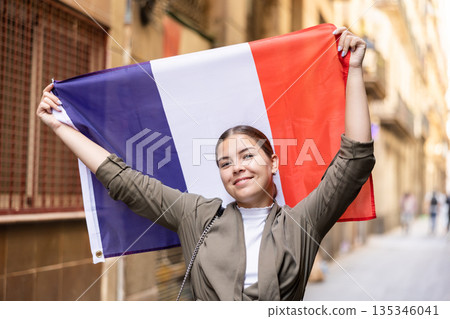 Young smiling woman holding France flag Young smiling woman holding France flag 135346041