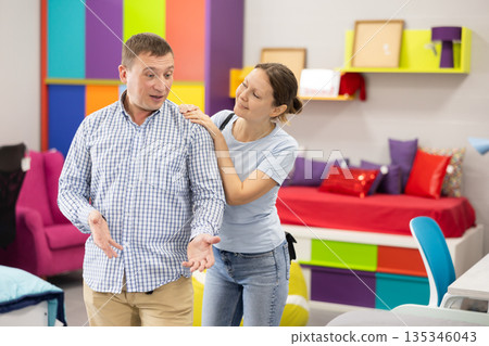 Couple choose and consider furniture in furniture store Couple choose and consider furniture in furniture store 135346043