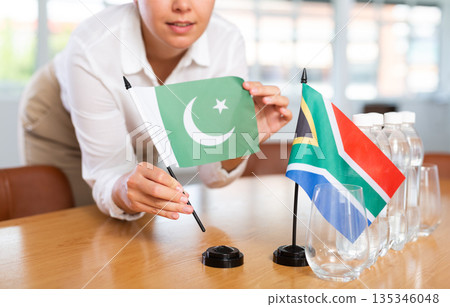 Businesswoman arranging the flags of Pakistan and South Africa for presentation and negotiations Businesswoman arranging the flags of Pakistan and South Africa for presentation and negotiations 135346048
