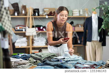 Woman scanning jeans in store 135346143
