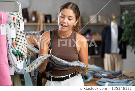 woman chooses a scarf and a handkerchief around her neck woman chooses a scarf and a handkerchief around her neck 135346152