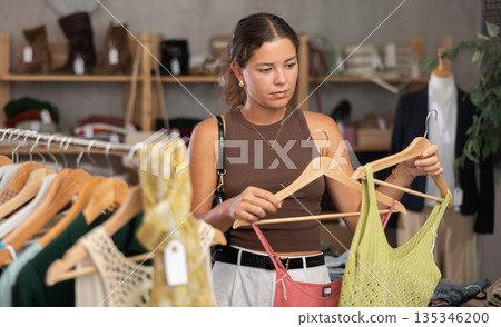 Distressed young woman customer in sales area of clothing store Distressed young woman customer in sales area of clothing store 135346200