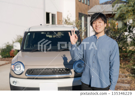 Smiling man standing in front of a car Smiling man standing in front of a car 135346229