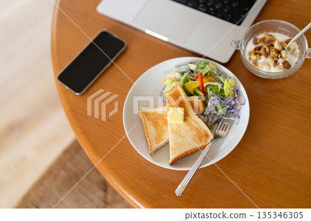 一張俯瞰視角的早餐場景照片，讓人聯想到在家工作或遠距辦公。 135346305