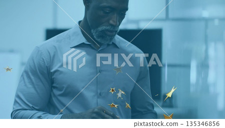 Gesturing African American man in light blue shirt working in office with gold stars and monitors 135346856
