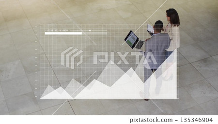 Two professionals wearing suits reviewing data overlay in lobby, with laptop, tablet, copy space Two professionals wearing suits reviewing data overlay in lobby, with laptop, tablet, copy space 135346904