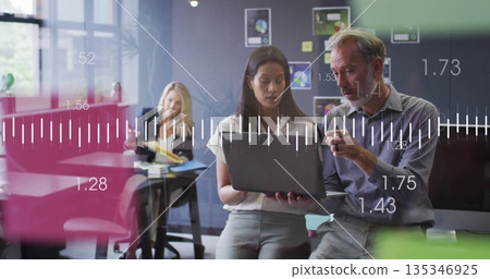 Reviewing analytics professional pair wearing business attire in office, with laptop coffee mug Reviewing analytics professional pair wearing business attire in office, with laptop coffee mug 135346925