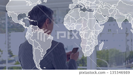 Businesswoman wearing pinstripe suit inspecting smartphone in office, with world map window overlay Businesswoman wearing pinstripe suit inspecting smartphone in office, with world map window overlay 135346989