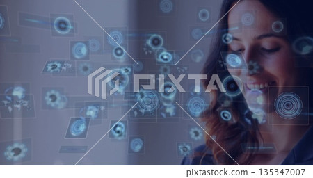 Data analyst analyzing holographic display panels with world map in modern office, copy space 135347007