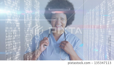 Smiling mid adult woman holding stethoscope in medical studio, with glowing code panels Smiling mid adult woman holding stethoscope in medical studio, with glowing code panels 135347113
