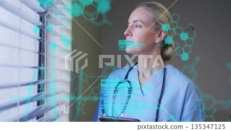 Reviewing data doctor in scrubs holding tablet at clinic window, with hologram overlays, copy space Reviewing data doctor in scrubs holding tablet at clinic window, with hologram overlays, copy space 135347125
